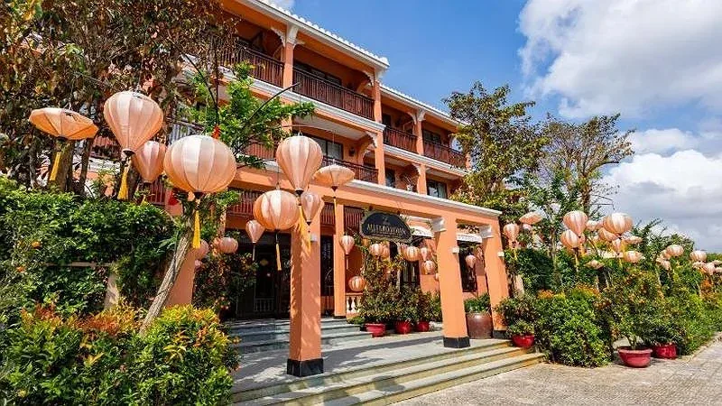 Lối vào Allegro Hoi An tường cam, ban công gỗ, đèn lồng lụa treo dày hai bên bậc thềm