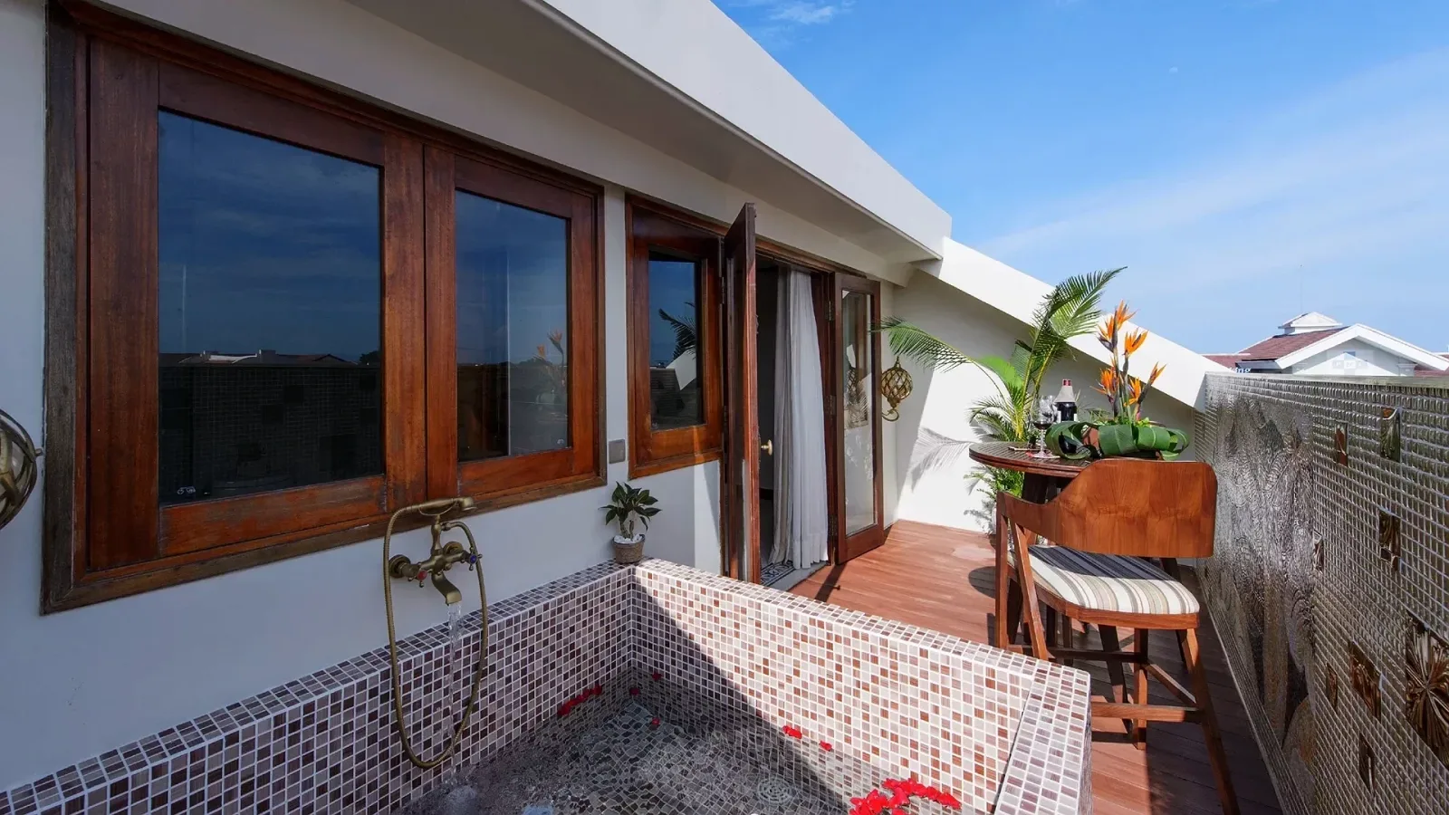 Bồn Jacuzzi lát mosaic rải cánh hoa đỏ trên sân thượng riêng của My Heart - Rooftop Jacuzzi Suite tại Almanity Hoi An