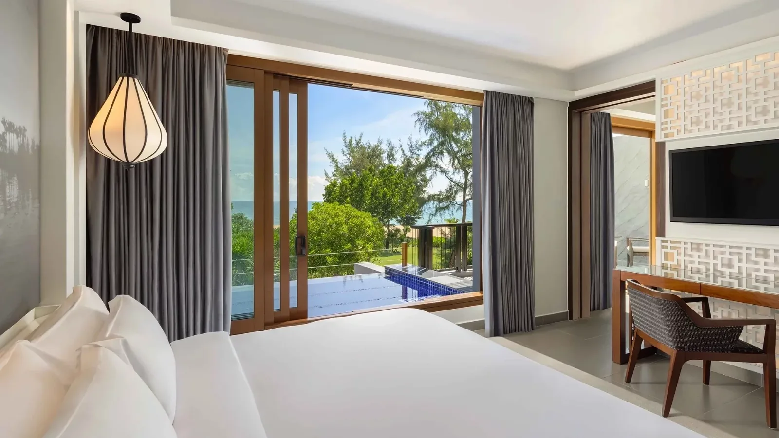 Phòng ngủ Sea View Junior Pool Suite ở Angsana Lăng Cô, cửa kính mở ra bể bơi riêng ngoài ban công, xa xa là biển