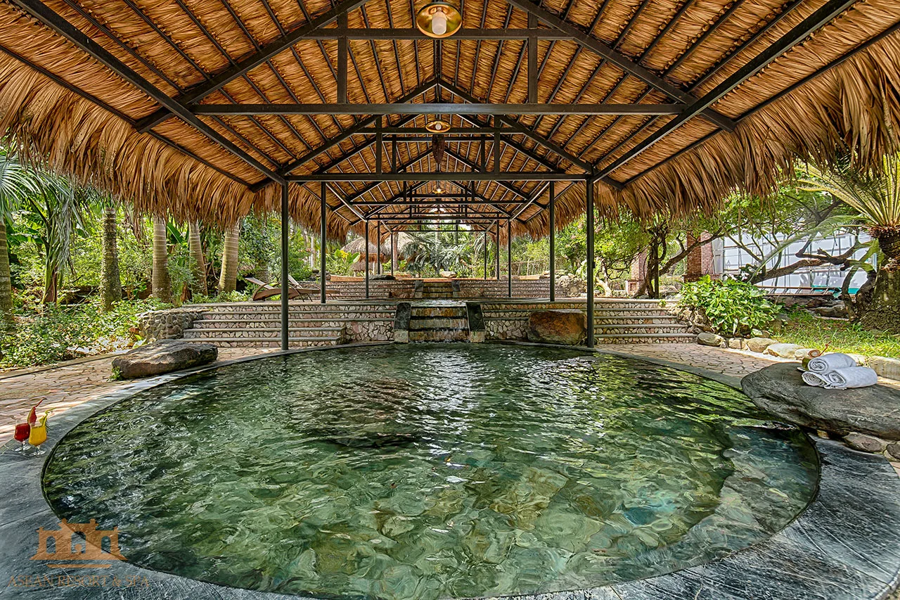 Bể ngâm tròn lát đá dưới mái lá khung thép tại Shiki Onsen, Asean Resort & Spa