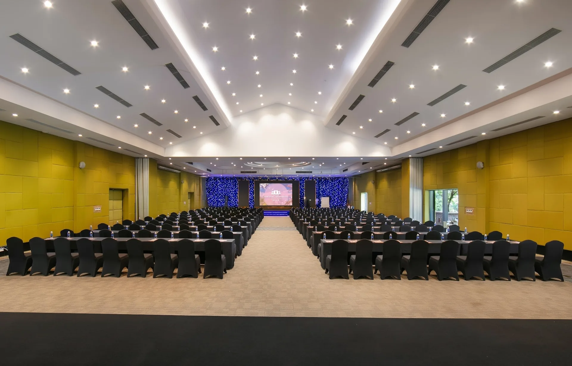 Hội nghị ASEAN tại Asean Resort & Spa kê bàn kiểu lớp học hai bên lối giữa, tường bọc nỉ vàng