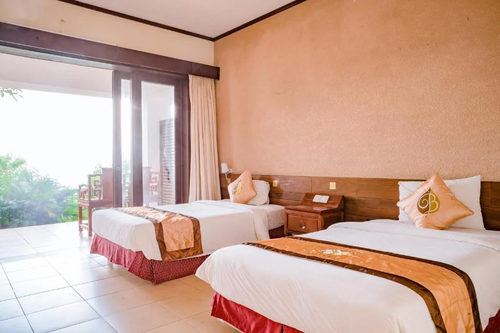 Phòng Deluxe Hướng Núi tại Belvedere Resort Tam Đảo với hai giường đơn, cửa kính mở rộng ra ban công và cây xanh trong sương