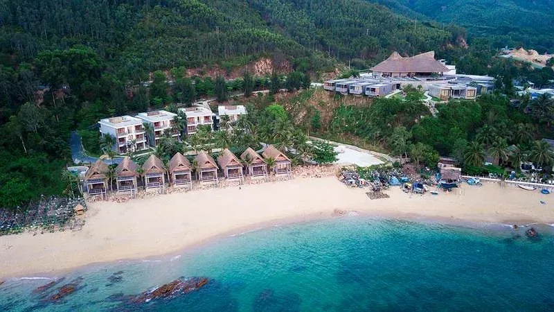 Casa Marina Resort Quy Nhơn nhìn từ trên cao, dãy bungalow mái lá sát bãi cát và làn nước xanh