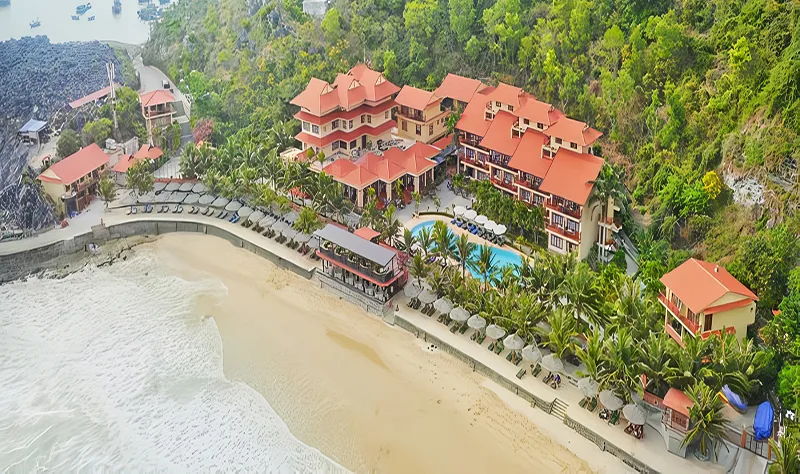 Toàn cảnh Cát Bà Sunrise Resort nhìn từ trên cao với các khối nhà mái đỏ, bể bơi giữa hàng dừa và bãi cát ngay phía trước