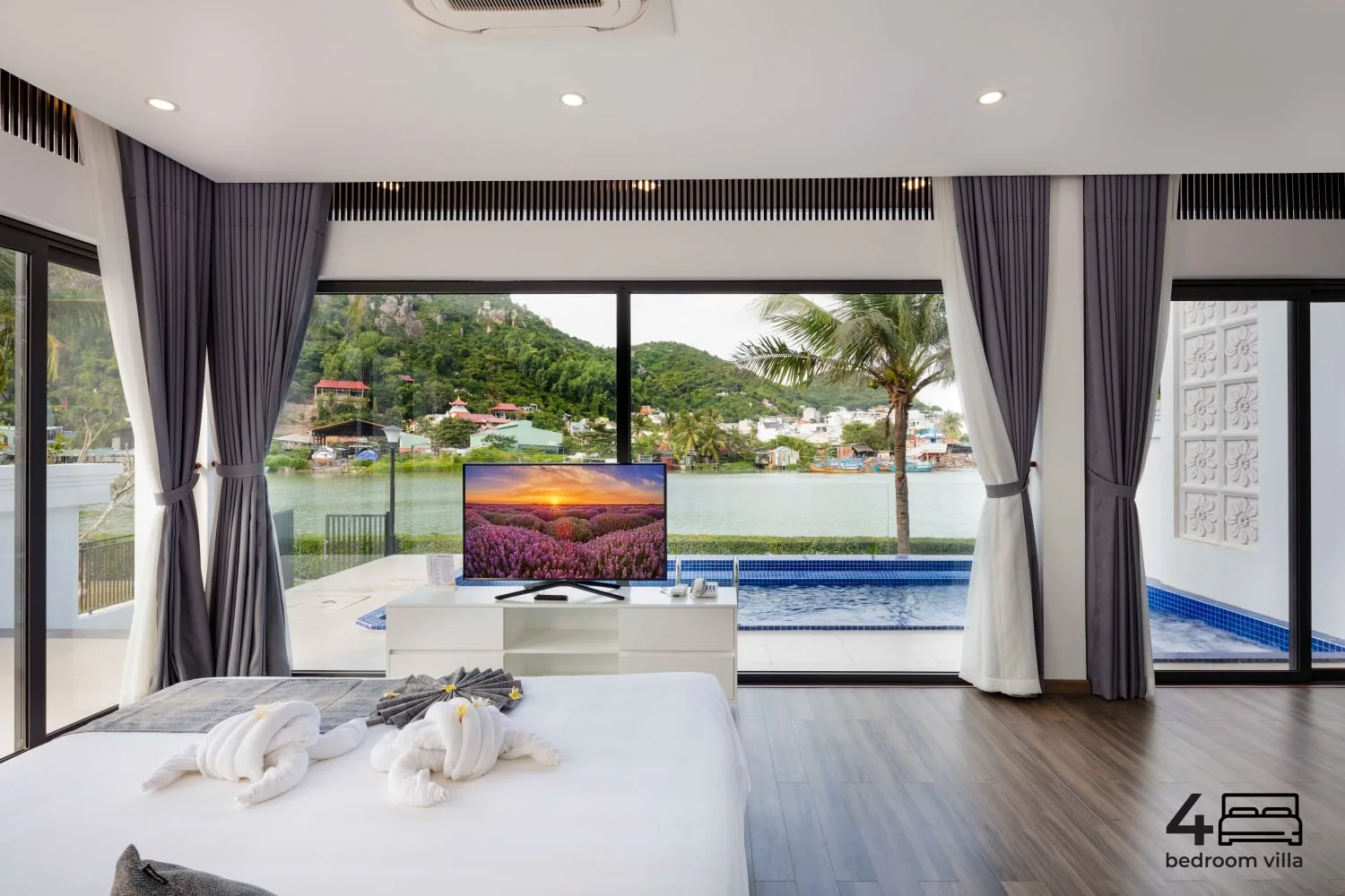 Phòng ngủ Presidential Villa 4 phòng ngủ tại Champa Island Nha Trang Resort Hotel & Spa, cửa kính lớn nhìn ra hồ bơi riêng, dòng sông và đồi xanh