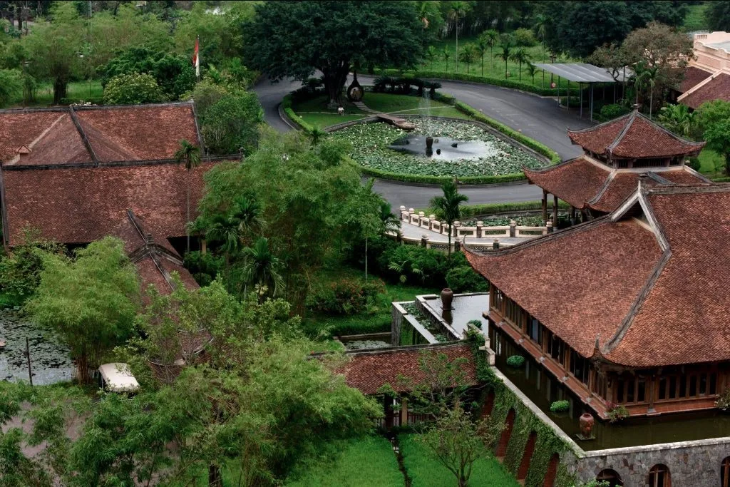 Mái ngói nâu kiểu đình làng và hồ sen trước sảnh Emeralda Resort Ninh Bình