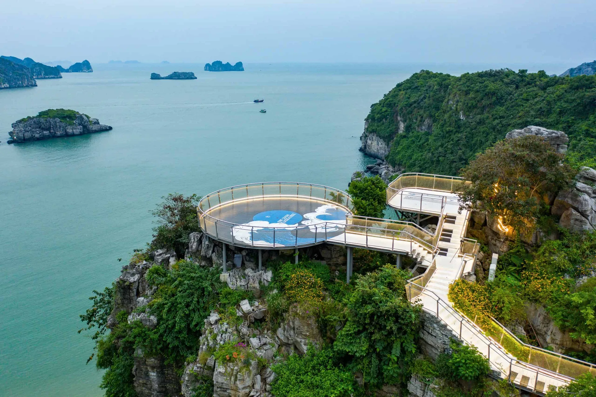 Đài ngắm cảnh tròn có lan can kính của Lan Hạ Panorama trên mỏm đá, nhìn ra vịnh Lan Hạ với các đảo đá vôi