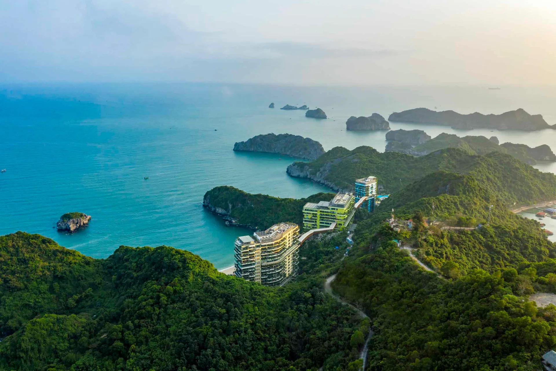 Toàn cảnh Flamingo Cát Bà từ trên núi: ba tòa nhà nối bằng cầu trên cao, rừng xanh và vịnh đảo đá phía xa