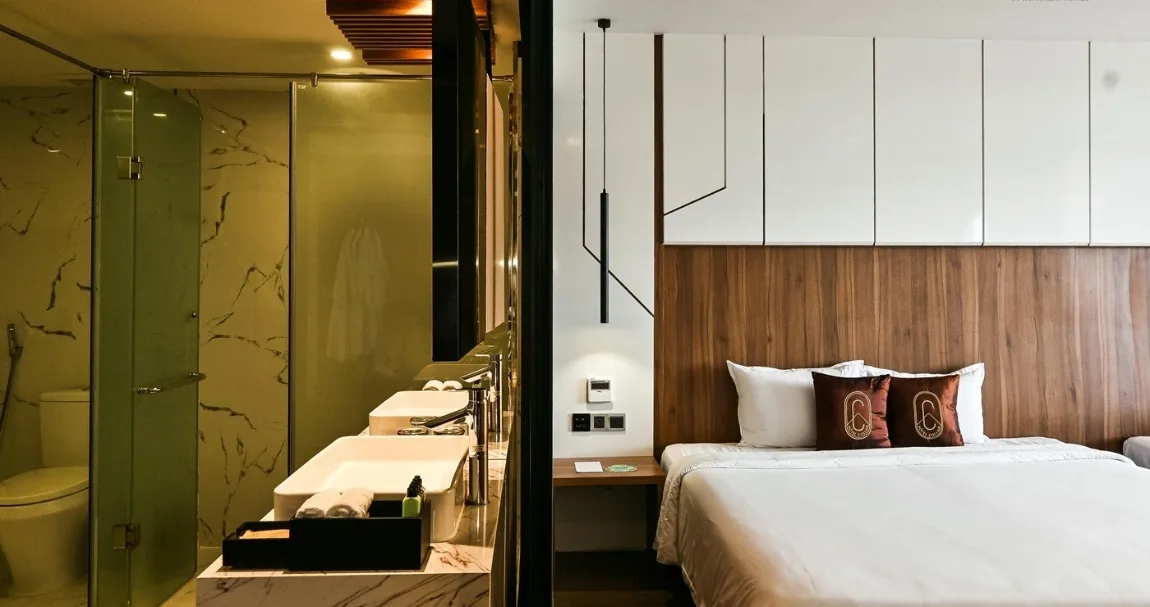 Phòng Deluxe của Hotel Colline Dalat với giường đôi, vách gỗ và phòng tắm kính ốp đá vân trắng