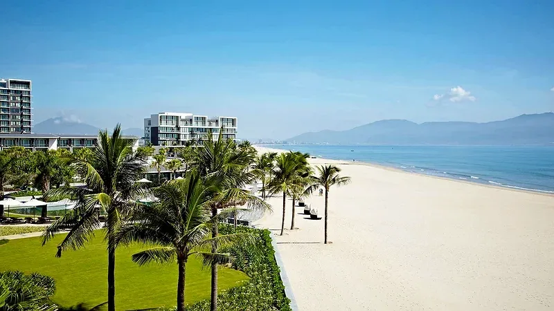 Bãi biển Non Nước cát trắng trước Hyatt Regency Danang Resort and Spa, hàng dừa và các tòa nhà thấp tầng của khu nghỉ