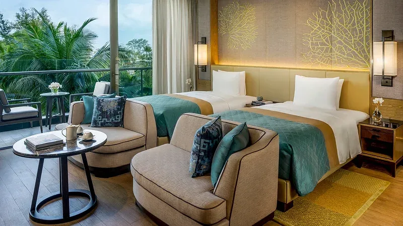Phòng có hai giường đơn, ghế bành và ban công nhìn ra vườn dừa trong hạng Family Suite - 2 phòng ngủ của InterContinental Phu Quoc Long Beach Resort