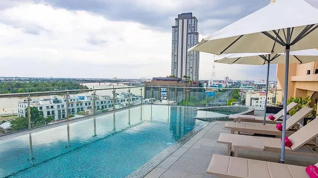 Bể bơi vô cực trên tầng thượng Iris Hotel Cần Thơ với ô dù trắng, ghế tắm nắng, lan can kính nhìn ra sông Hậu và thành phố