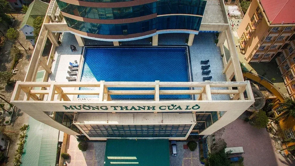 Bể bơi ngoài trời trên cao của Mường Thanh Grand Cửa Lò nhìn từ flycam, ghế tắm nắng xếp hai bên