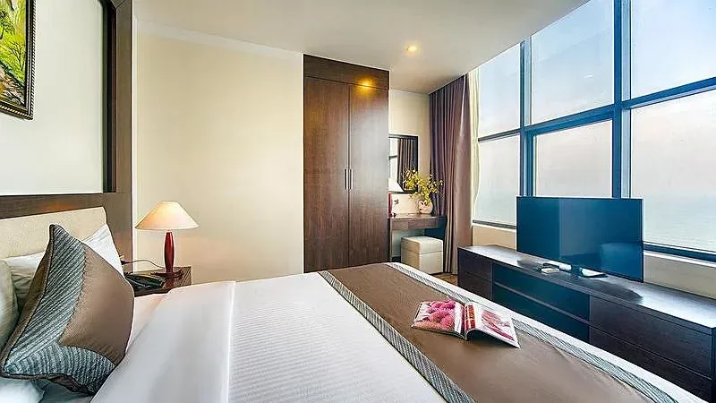 Phòng Deluxe King Hướng Biển của Mường Thanh Grand Cửa Lò, giường đôi và vách kính lớn nhìn ra biển