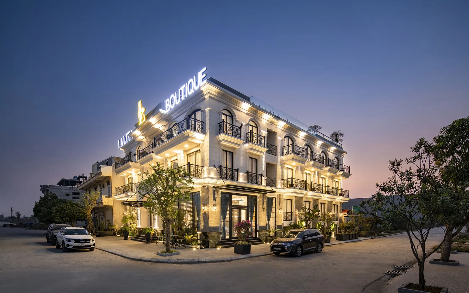 Mặt tiền trắng kiểu tân cổ điển với ban công sắt uốn và biển tên lên đèn của Lalita Boutique Hotel & Spa Ninh Bình
