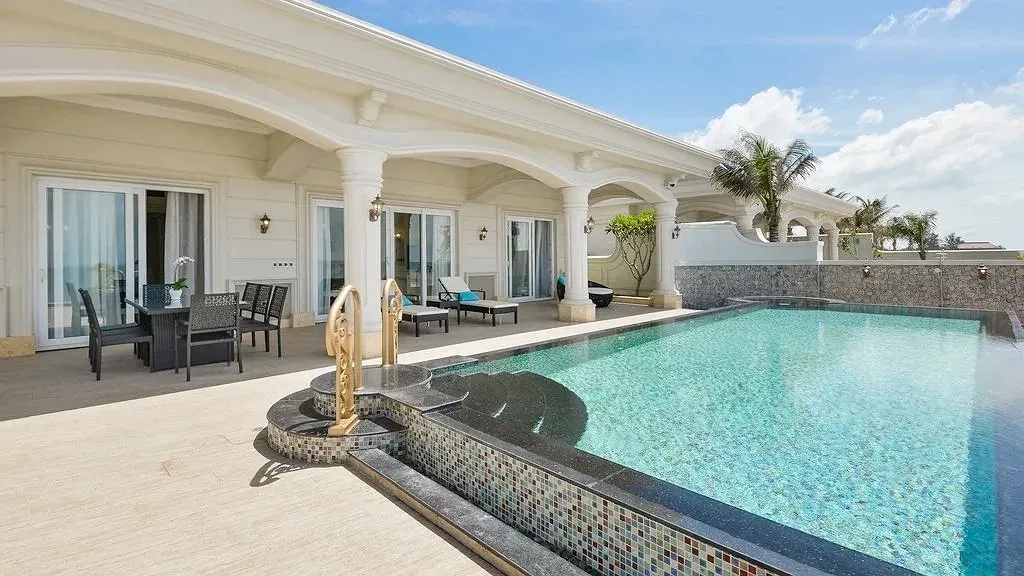 Beachfront Pool Villa ở Lan Rừng Resort & Spa Phước Hải: hiên vòm cột trắng kiểu châu Âu, bàn ăn ngoài trời và hồ bơi riêng lát gạch mosaic