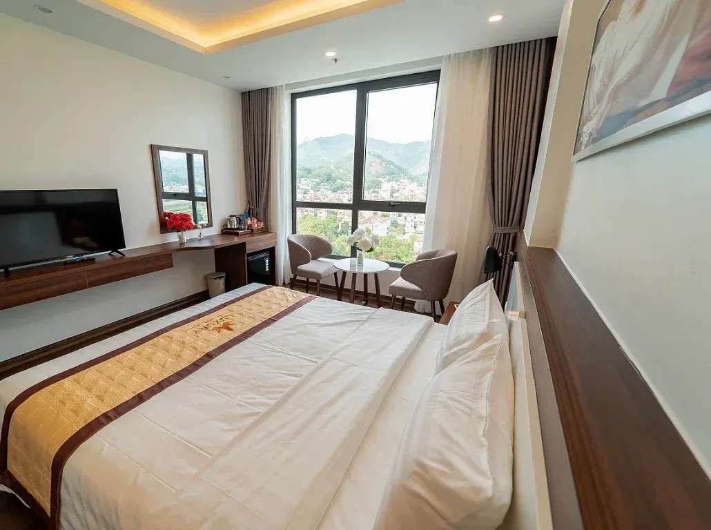 Phòng Deluxe City View của Luxury Hotel One Cao Bằng, cửa kính lớn nhìn ra phố núi