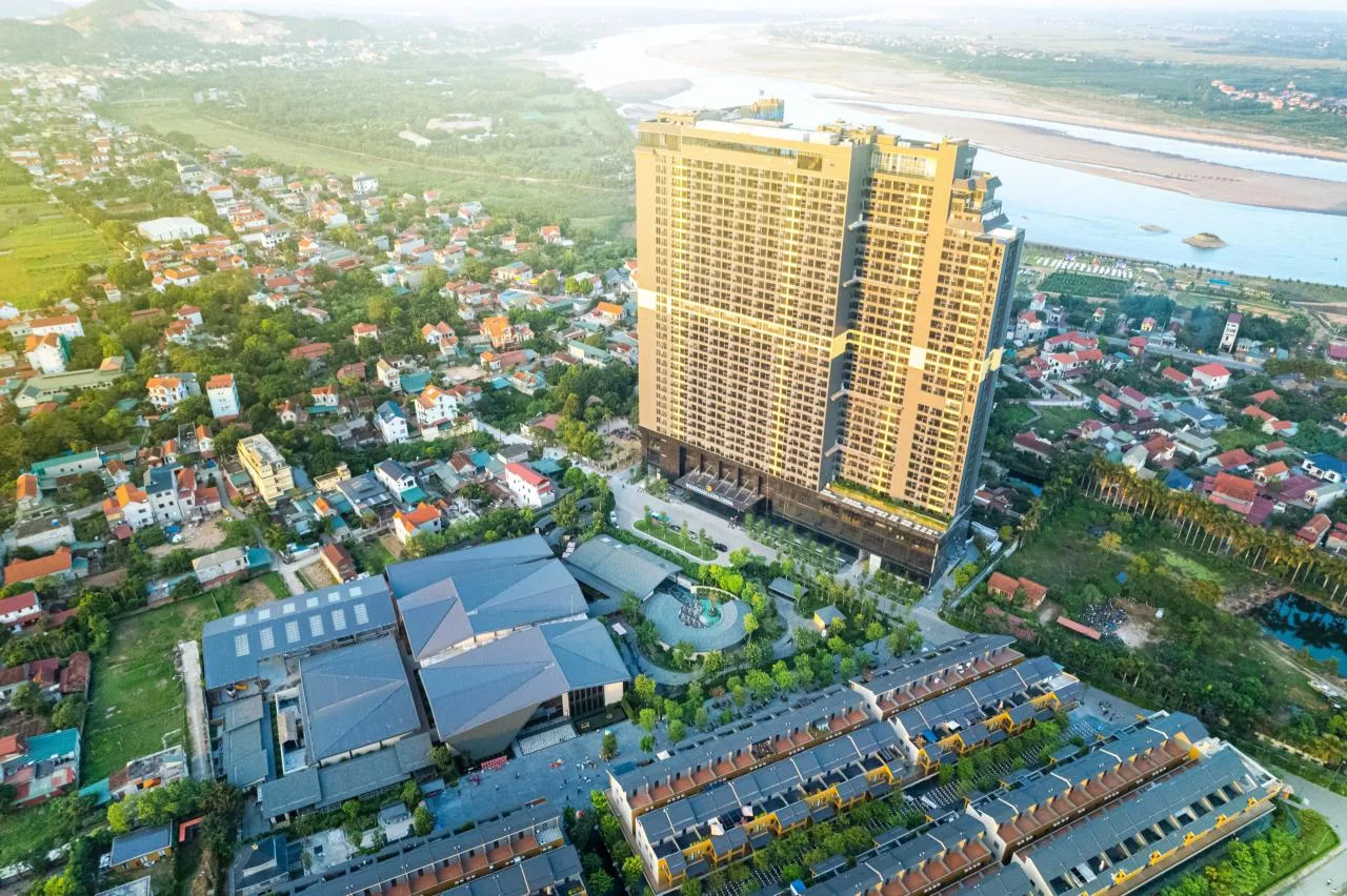 Toàn cảnh Lynntimes Thanh Thủy từ trên cao với tòa khách sạn cao tầng màu vàng, mái công viên Ohayo, dãy Shoptel và sông Đà phía sau