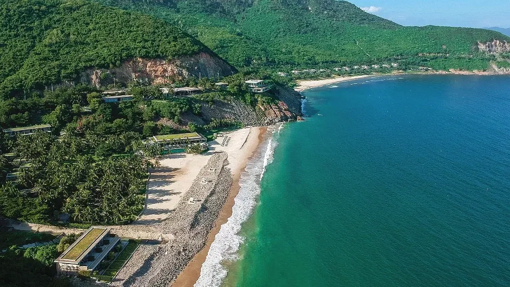 Toàn cảnh Mia Resort Nha Trang từ trên cao: các căn villa nép trên triền đồi xanh, bãi cát nhỏ và vịnh nước xanh ngọc