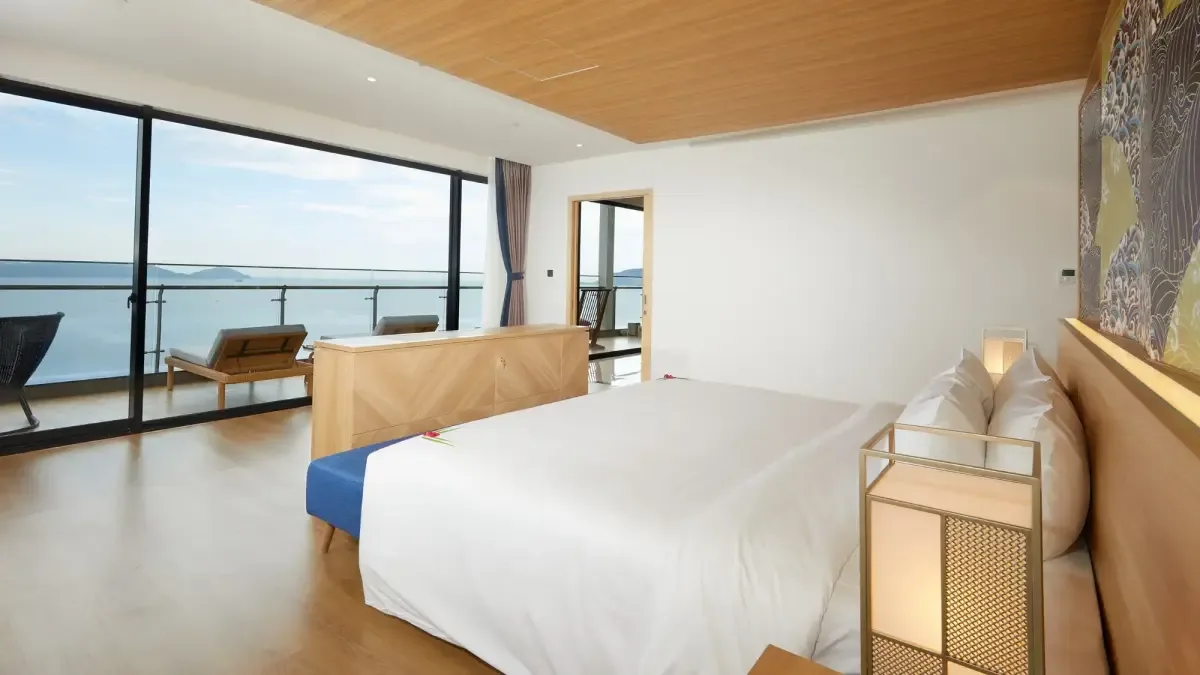 Phòng ngủ Executive Suite Ocean View tại Mikazuki với giường lớn, tranh sóng kiểu Nhật và cửa kính nhìn ra biển