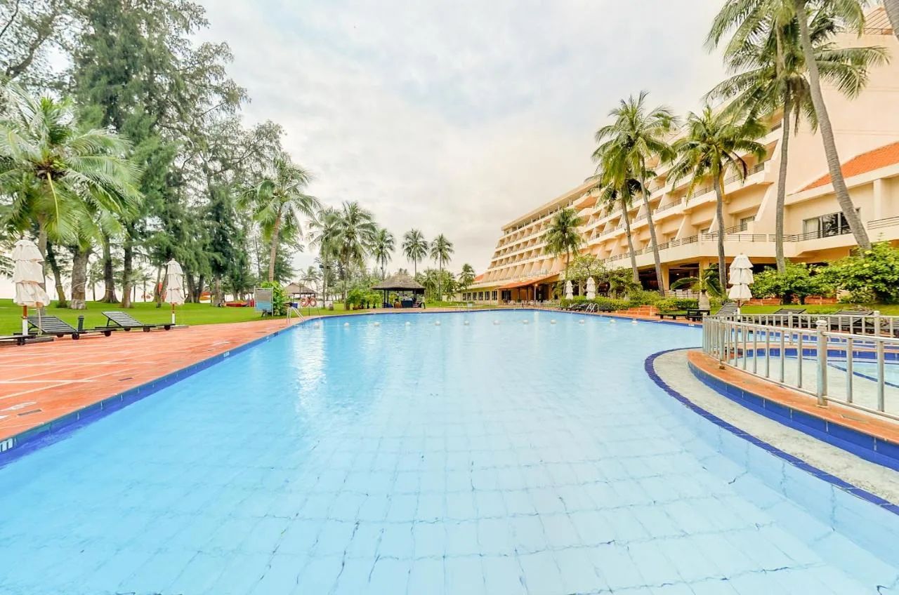 Hồ bơi rộng lát gạch xanh trước khối nhà bậc thang và hàng dừa của Phan Thiet Ocean Dunes Resort