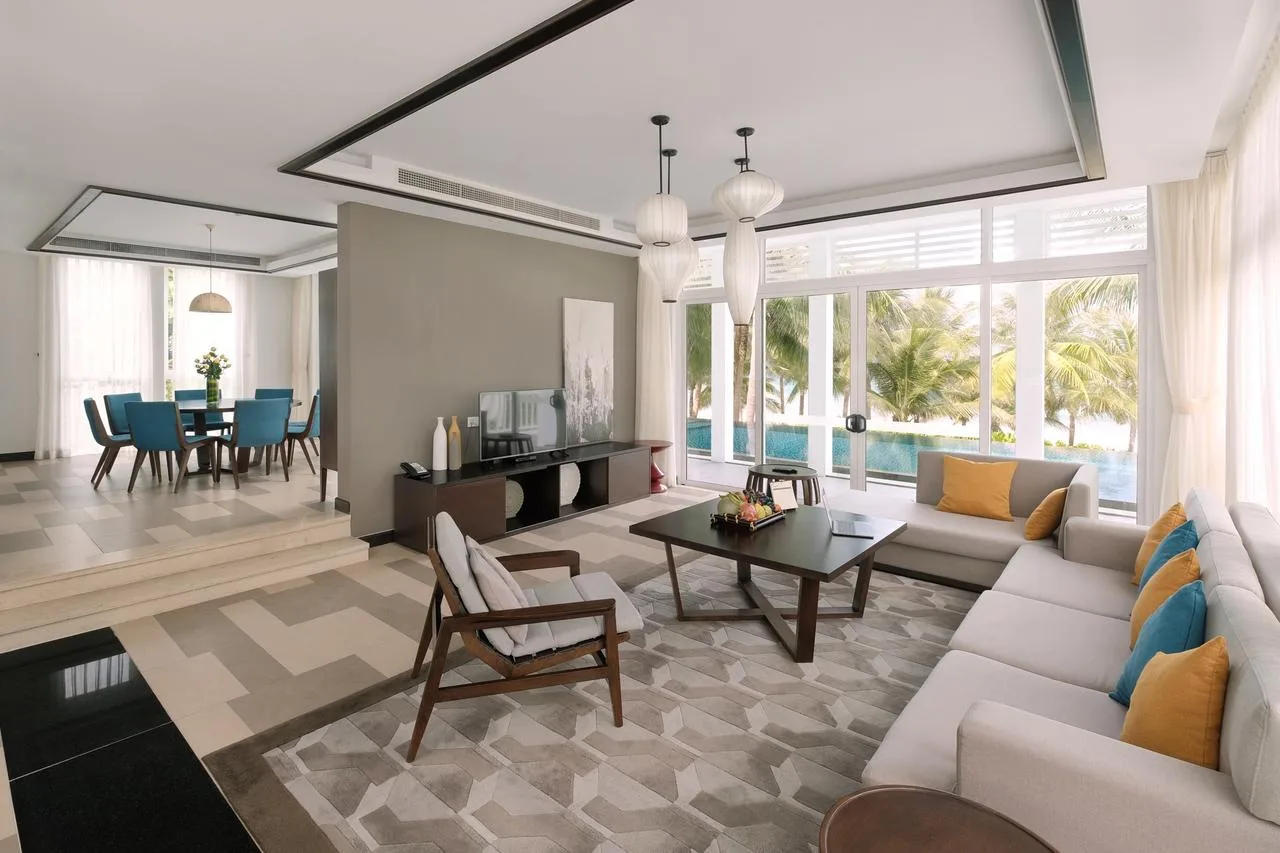Phòng khách villa Premier Village Danang, cửa kính mở ra hồ bơi riêng và hàng dừa