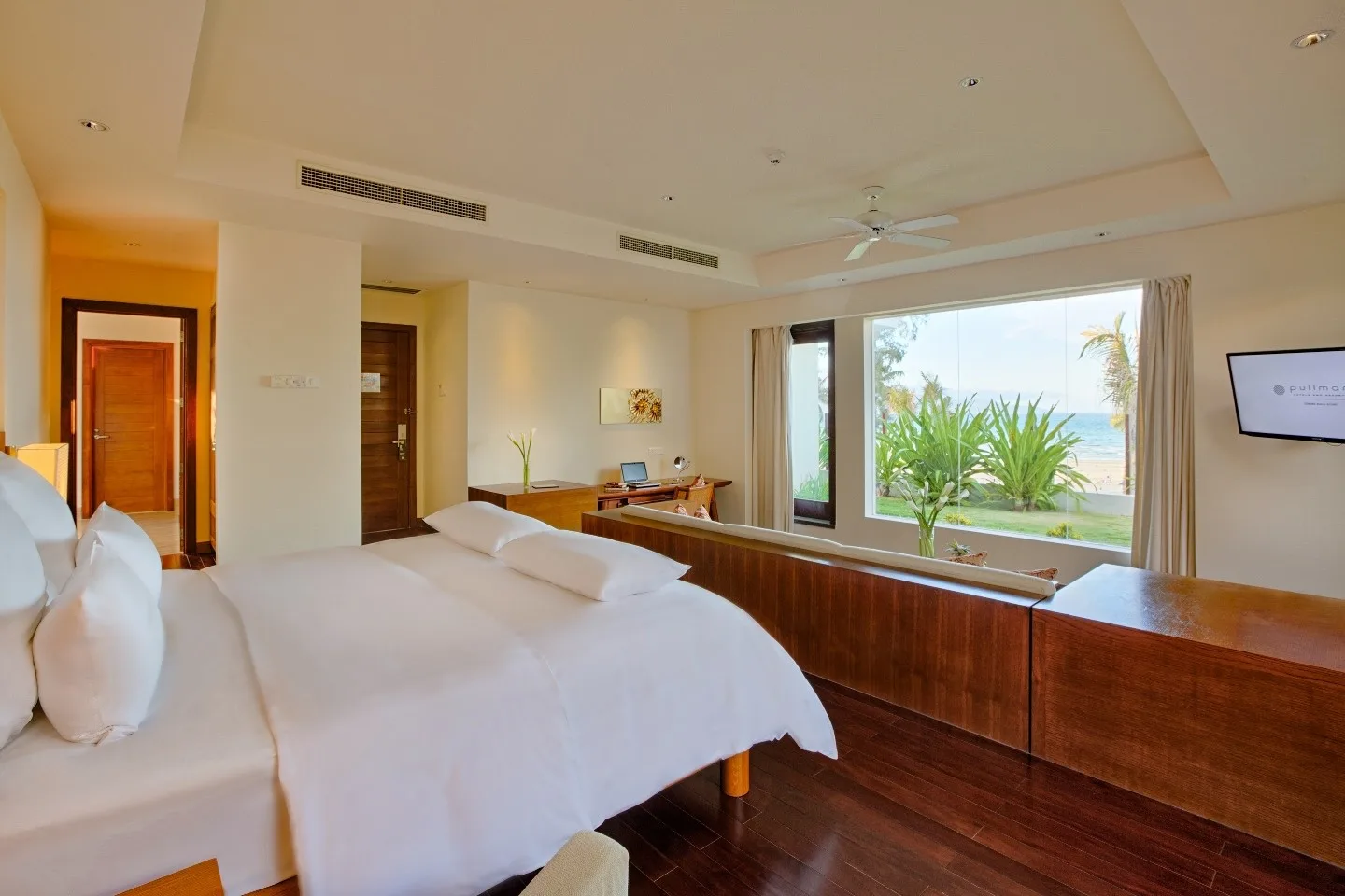Phòng ngủ Two-Bedroom Beachfront Cottage của Pullman Đà Nẵng, cửa kính lớn nhìn ra vườn và biển