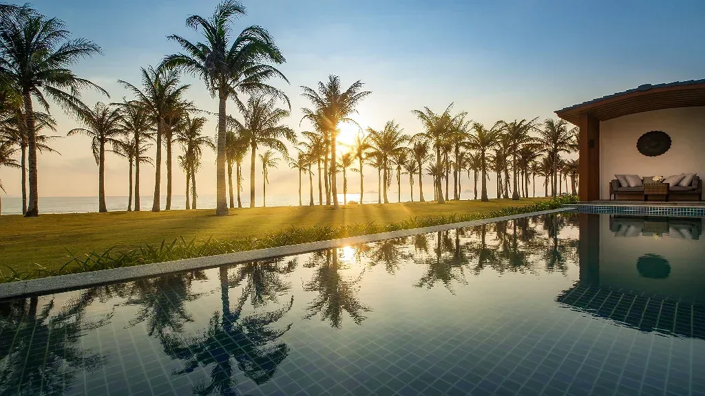 Hồ bơi riêng villa Radisson Blu Resort Cam Ranh lúc hoàng hôn, hàng dừa và biển phía sau