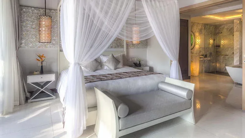 Phòng ngủ Pearl Suite Villa tại Salinda Resort Phu Quoc Island với giường màn trắng và phòng tắm có bồn