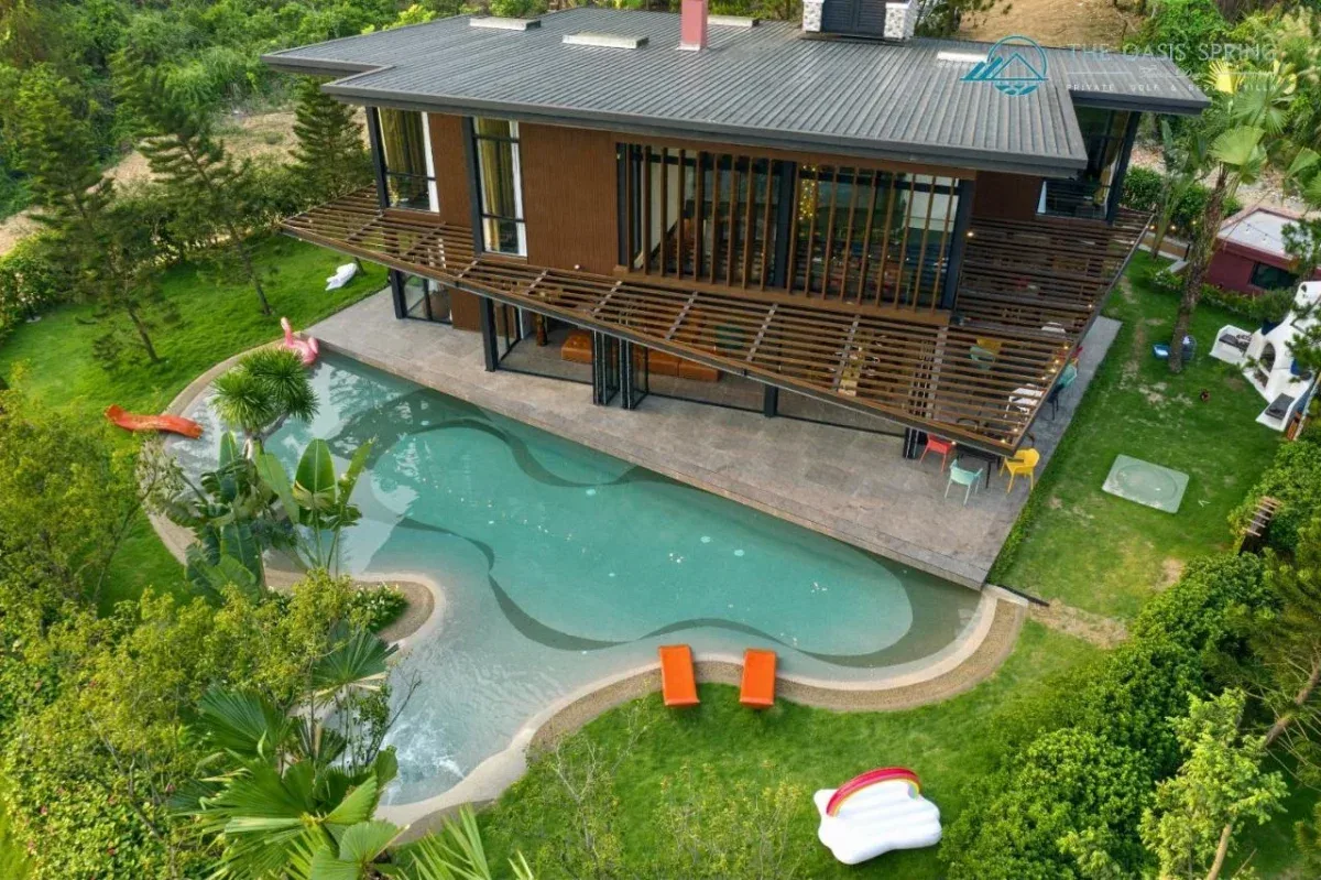 Villa Tam Đảo Golf & Resort nhìn từ trên cao, hồ bơi riêng uốn cong ôm sát hiên nhà gỗ, xung quanh là bãi cỏ và cây xanh