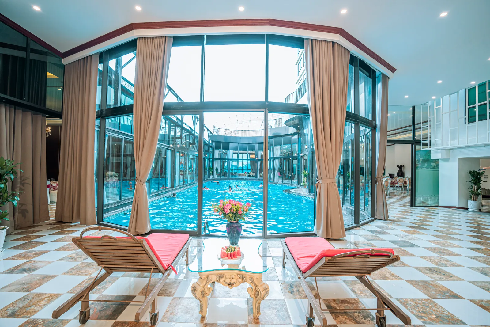 Bể bơi trong nhà có vách kính và ghế thư giãn tại The Vissai Hotel Ninh Bình