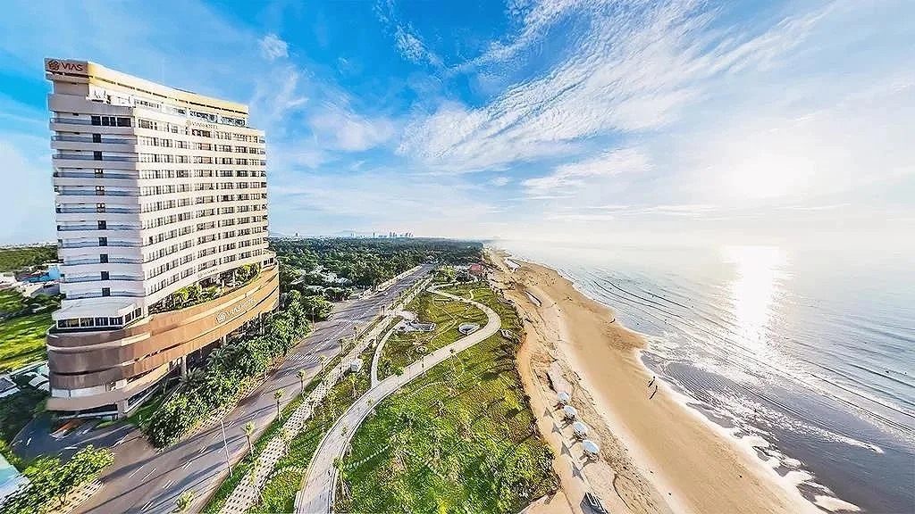 Tòa khách sạn Vias Hotel Vung Tau nhìn từ trên cao bên đường Thùy Vân, dải công viên xanh và bãi cát Bãi Sau trải dài dưới nắng sớm