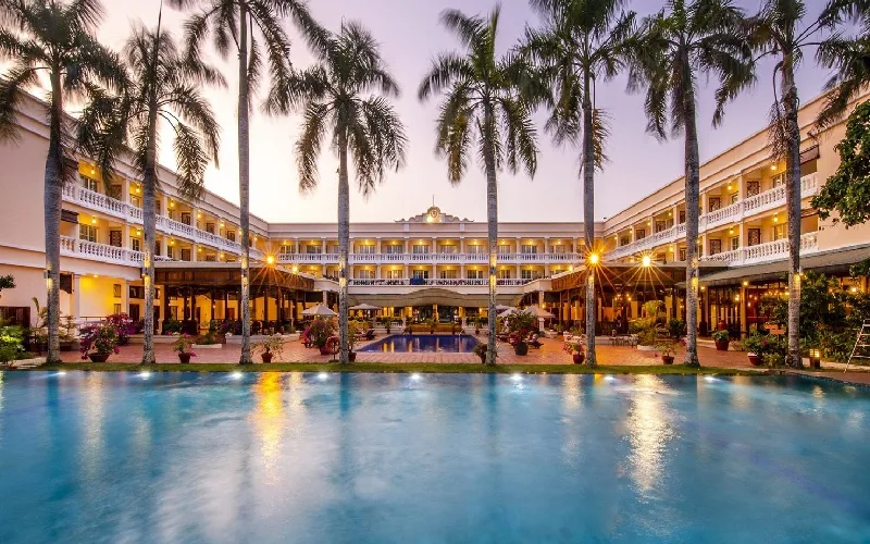 Hồ bơi và các dãy nhà mái ngói hàng cột dừa của Victoria Cần Thơ Resort lúc lên đèn