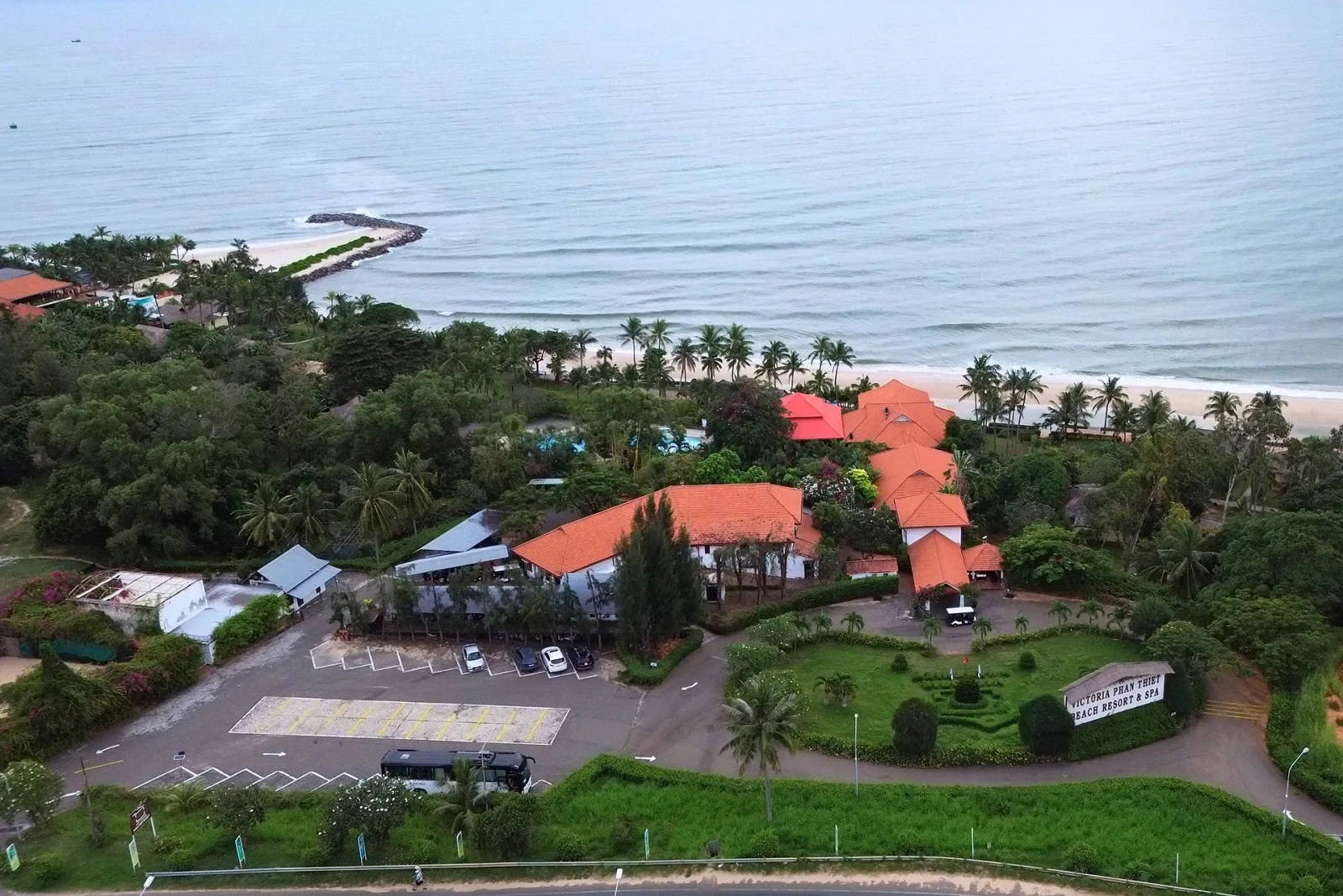 Victoria Phan Thiet Beach Resort & Spa nhìn từ trên cao, nhà mái ngói cam giữa vườn cây, phía sau là biển
