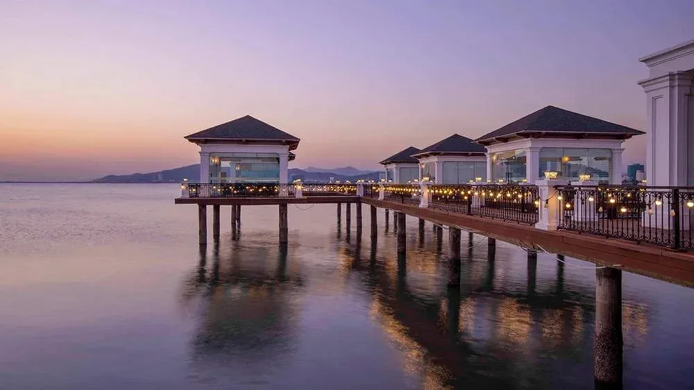 Dãy nhà hàng nổi dựng trên cọc giữa mặt vịnh của Vinpearl Resort & Spa Hạ Long lúc chạng vạng