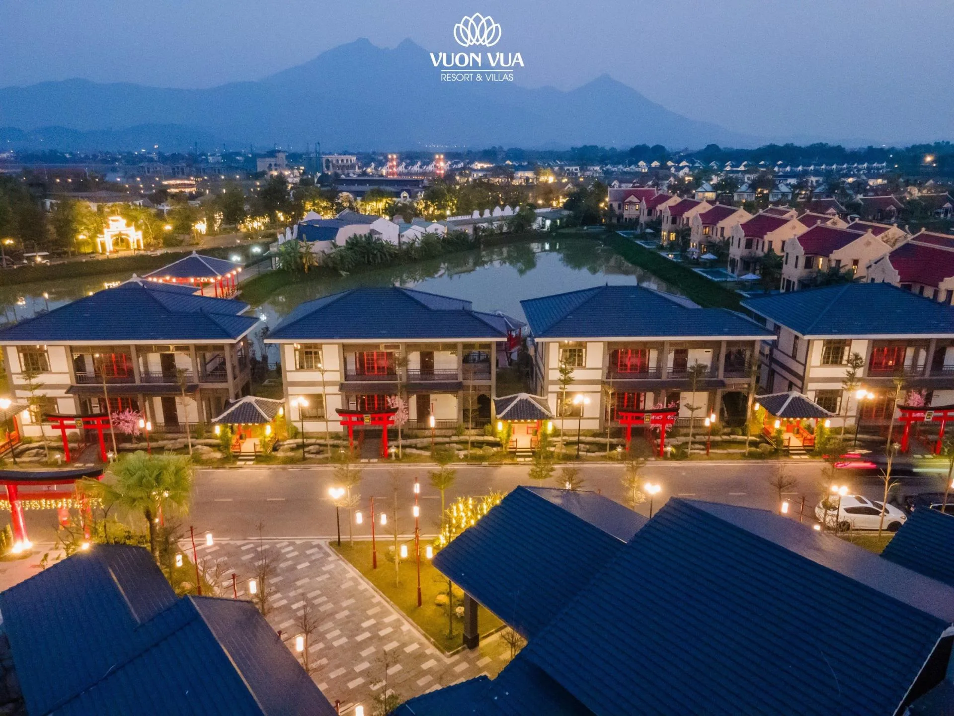 Khu villa kiểu Nhật với cổng torii đỏ trong Vườn Vua lúc chạng vạng, phía sau là núi Ba Vì