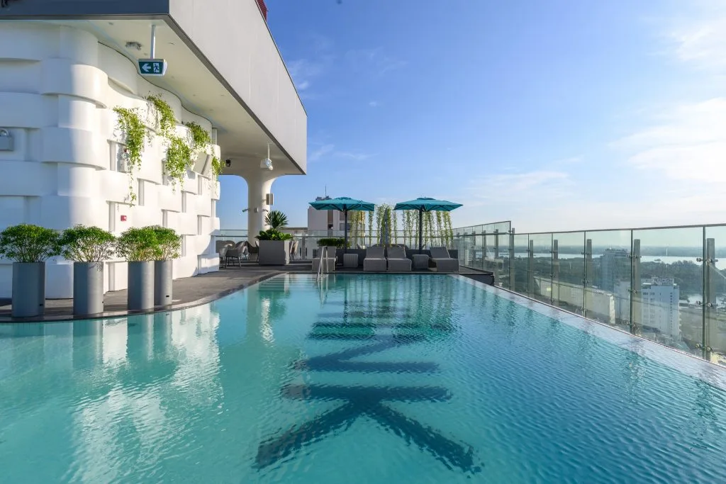 Hồ bơi vô cực trên tầng thượng Wink Hotel Cần Thơ, lan can kính nhìn ra thành phố và sông