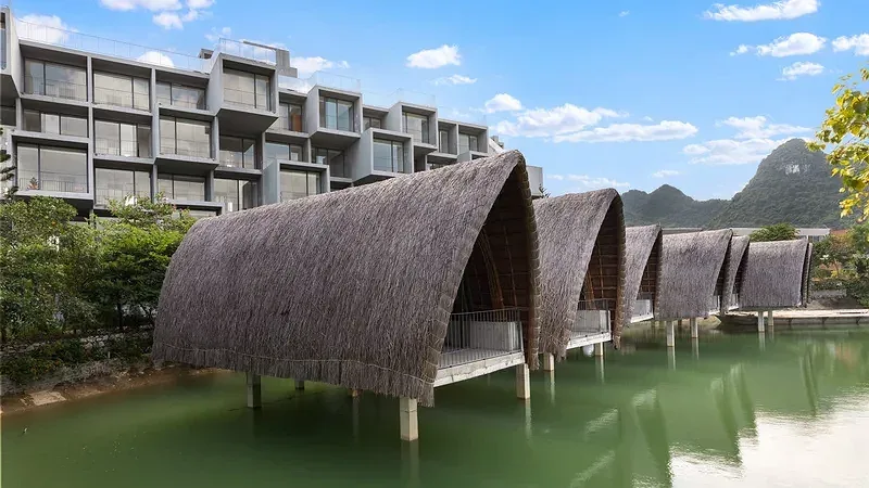Dãy bungalow mái tranh vòm cong dựng trên mặt hồ ở thôn Đồng Tâm, nay thuộc Wyndham Grand Vedana Ninh Binh Resort, núi đá vôi phía xa