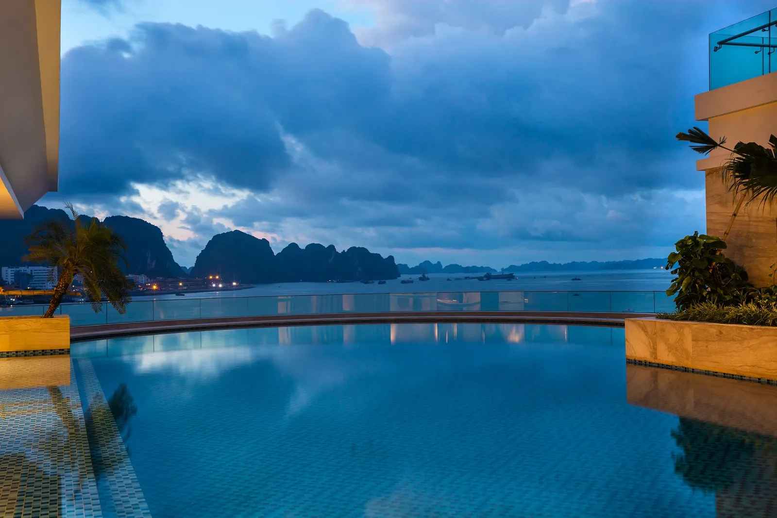 Bể bơi vô cực của Wyndham Legend Halong nhìn ra dãy núi đá vôi và vịnh Hạ Long lúc chạng vạng