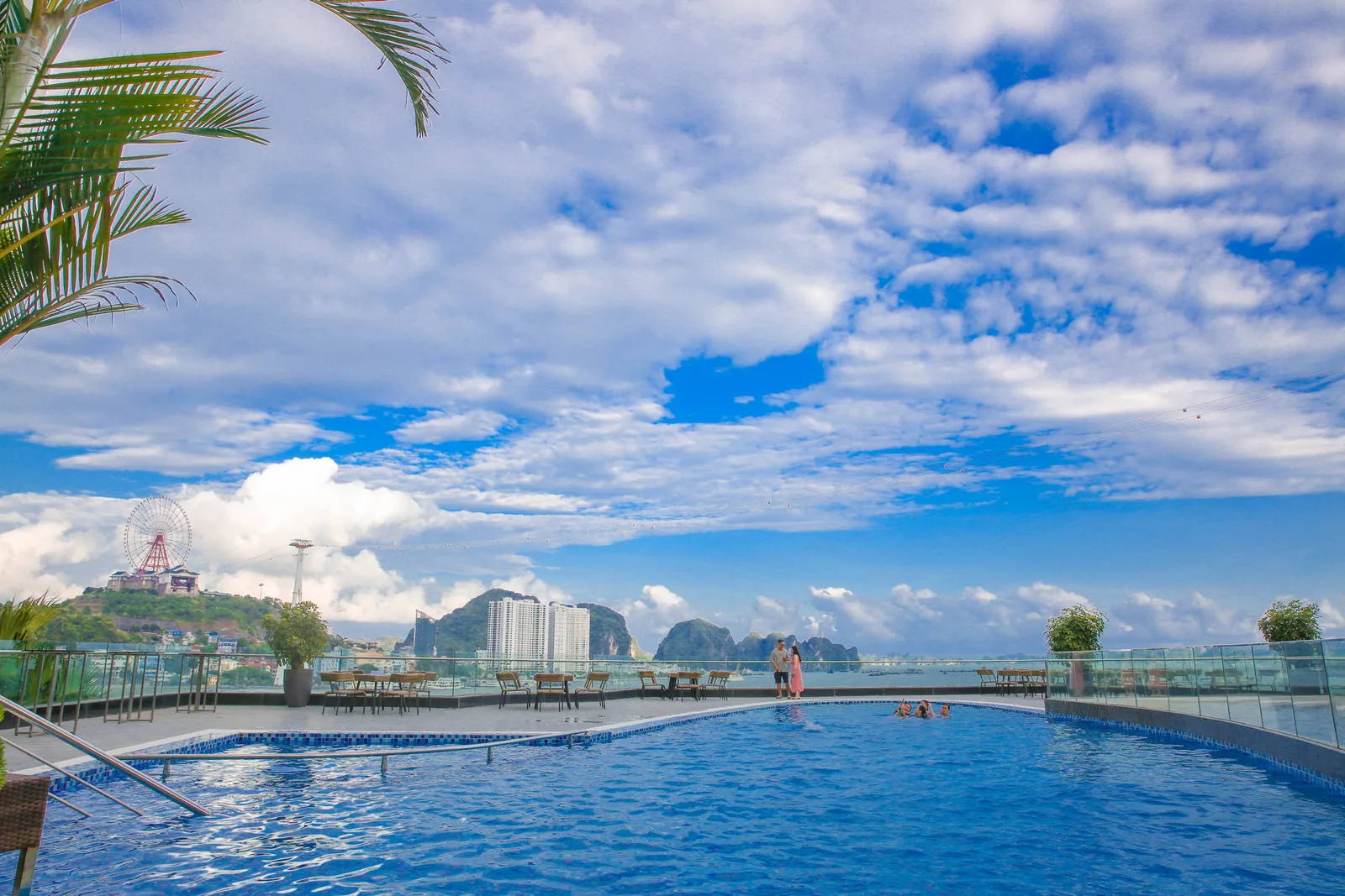 Bể bơi ngoài trời trên cao của Wyndham Legend Halong, xa xa là vòng quay Mặt Trời và núi đá vịnh Hạ Long